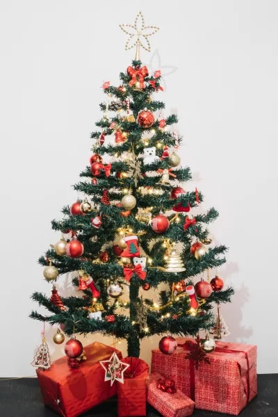 artificial christmas tree with presents under it